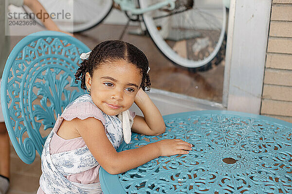 little girl enjoys summer while sitting outside a local boutique