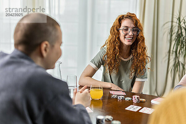 enjoying friends sitting at table and play card games