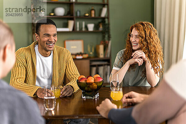 multiracial friends hanging out together at home sitting and chatting