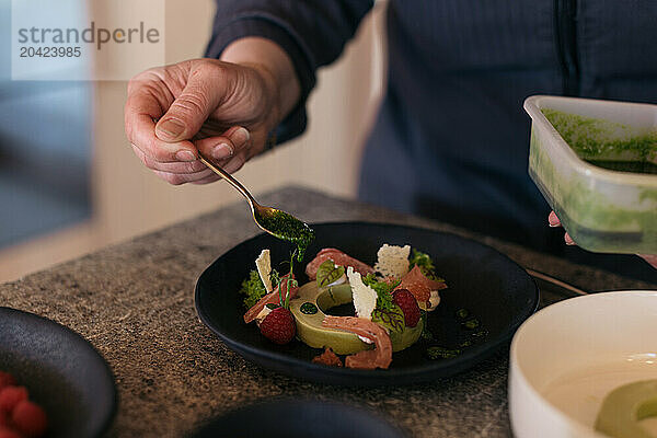 Chef plating a gourmet dish with fresh ingredients and garnishes