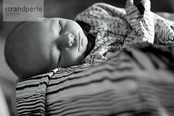 Serene newborn sleeping peacefully on grandma's arm