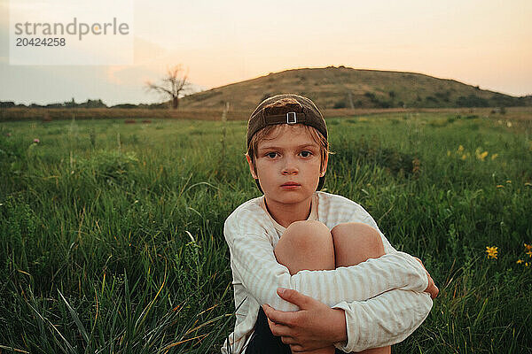 Calm and relaxed child enjoying on grass field and dreaming