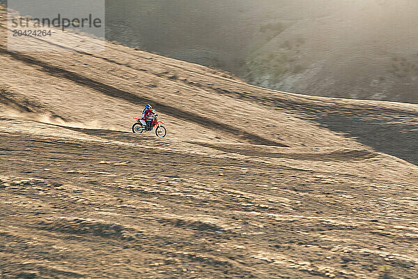 Skilled father and son riding on a dirt bike together.