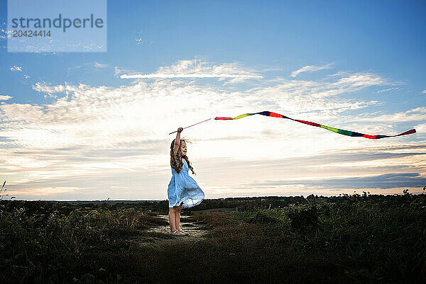 Happy little girl playing with kite in summer