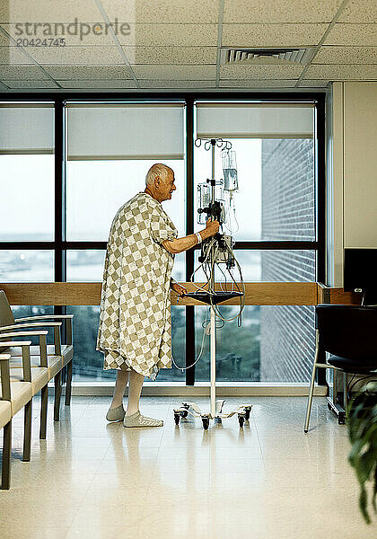 elderly male cancer patient smiles while taking walk in hospital