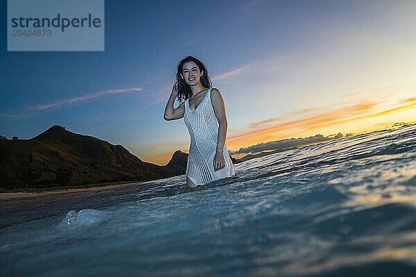 beautiful woman enjoying wading through the ocean in Komodo