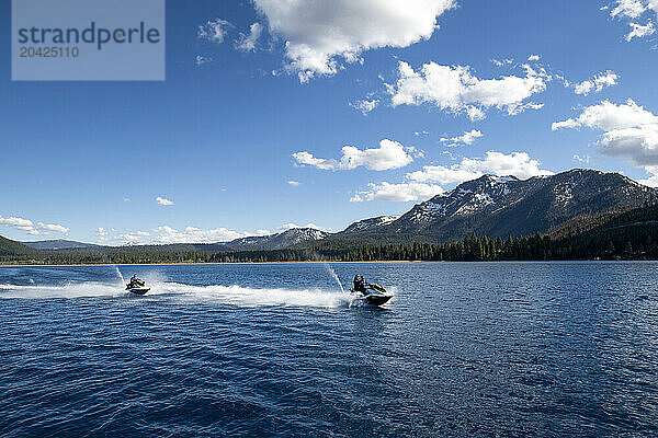 Three friends ride WaveRunners at the base of Mount Tallac.