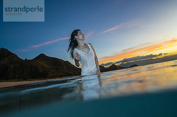 beautiful woman enjoying wading through the ocean in Komodo