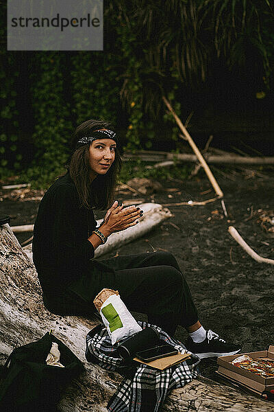 Young woman on the beach in a picnic on the ocean.