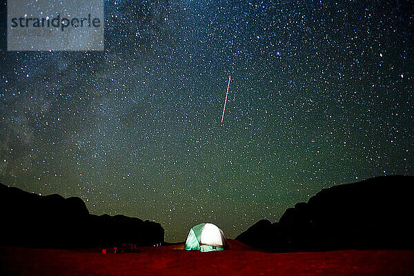 A shooting star lights up the sky above a tent in Grand Staircase-Escalante National Monument in Utah.