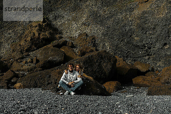 Couple amidst basalt columns of the Reynisfjara beach.