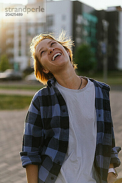 Headshot of laughing woman in the street.