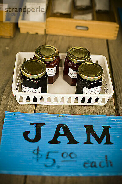 Fresh jam and other goods out by the road for sale.