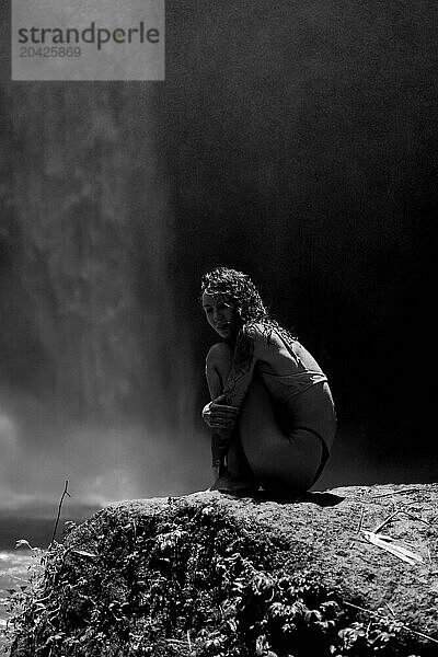 Woman traveler at the waterfall Nung Nung. Black and white. Bali