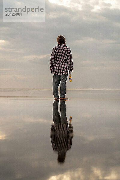 Happy man at sunset on the ocean beach.