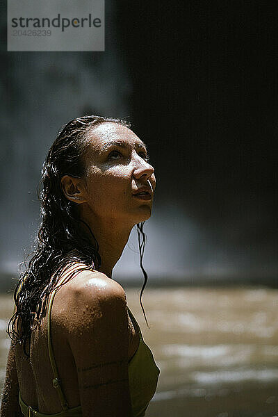 Woman traveler at the waterfall portrait close-up