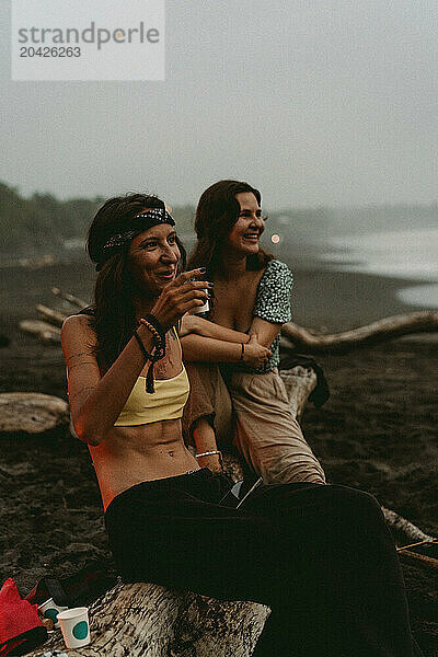 Friends having a picnic on the beach near the ocean.