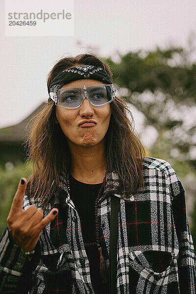 Portrait of a woman wearing a bandana and stylish blue sunglasses.