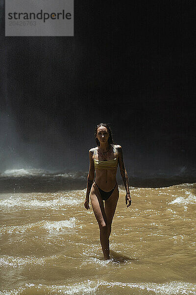 Woman traveler at the waterfall Nung Nung. Bali