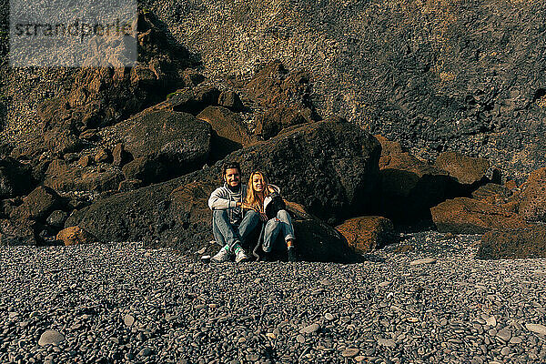 Couple amidst basalt columns of the Reynisfjara beach.