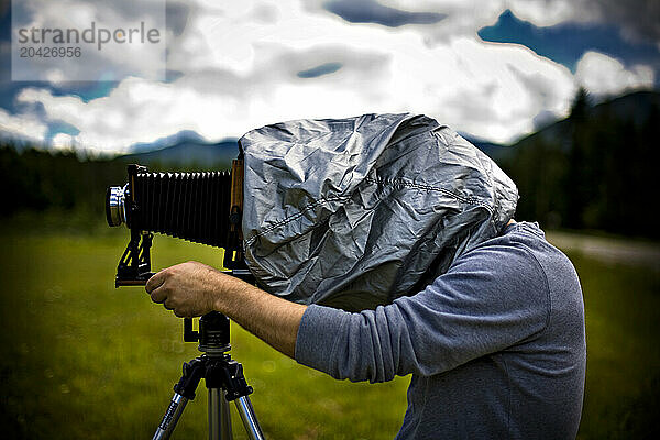 A man takes a photograph with his large format camera in a field near Leigh Lake in Montana.