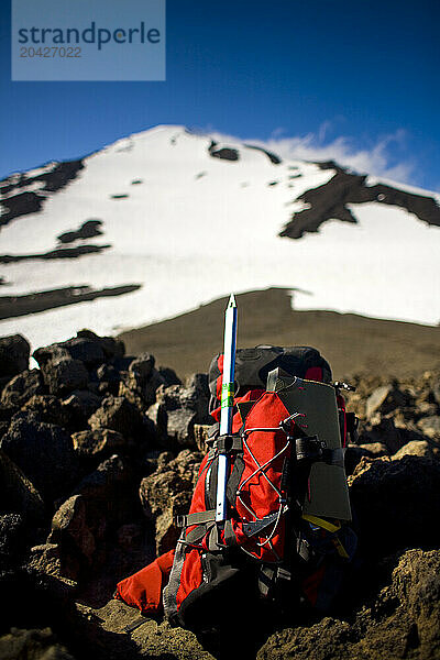 A backpack sits on rocks with the summit of Mount Adams in the distance in Washington.