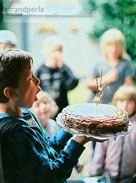 Boy blowing candles on birthday cake