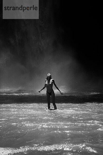 Woman traveler at the waterfall Nung Nung. Black and white. Bali