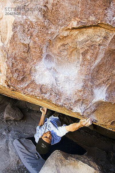 A Young African American man boulders in Hueco Tanks State Park near El Paso  Texas.