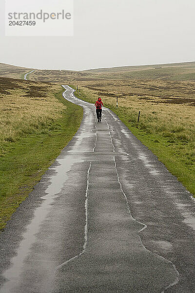 Person walking away on a small country road.