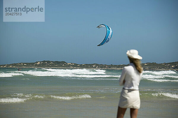 Girl watches kiteboarder  Still Baai  South Africa