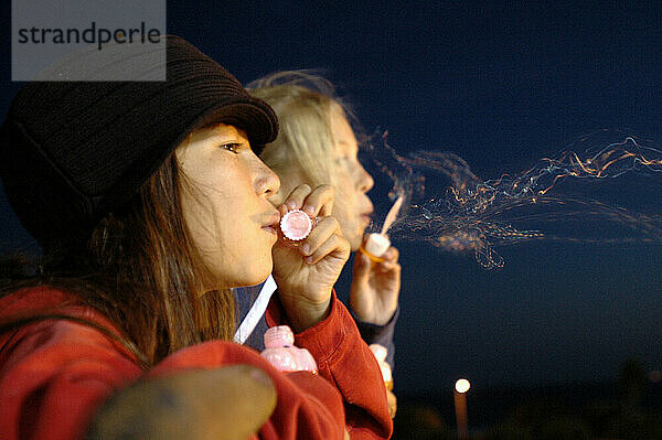 Two young girls blowing bubbles