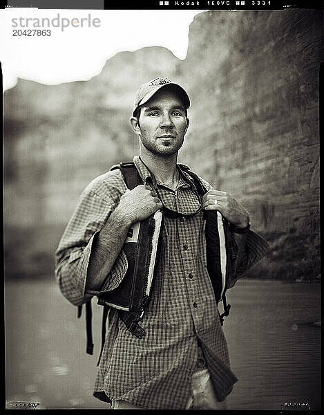 A river guide stands by the Colorado River in Grand Canyon National Park  Arizona  wearing his lifejacket