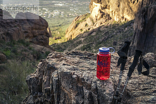 Red Water Bottle With Two Hiking Poles On Rock  Superstition Mountains  Arizona  Usa