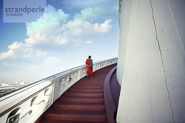 Monks are going up the stairs to reach the temple