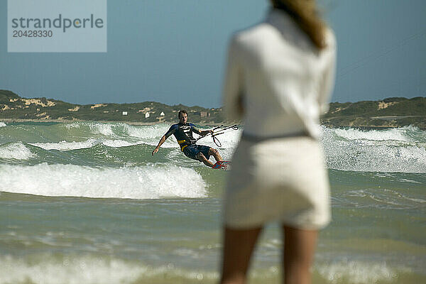 Girl watches kiteboarder  Still Baai  South Africa.