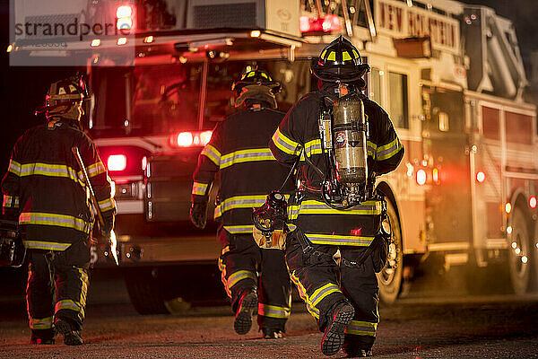 Three firefighters with different fire equipment  New Holstein  Wisconsin  USA