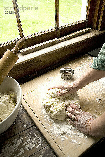 Woman preparing to bake biscuits  kneading the dough.