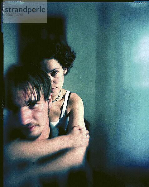 Color portrait using selective focus of a young couple bathed in green light