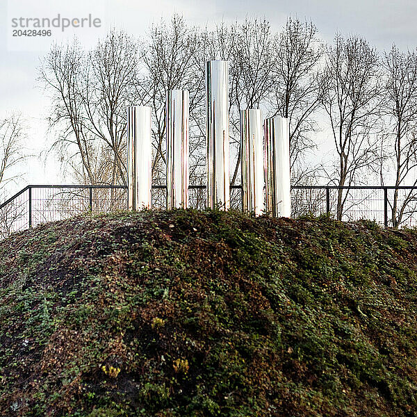 An art installation of metal tubes in a park.