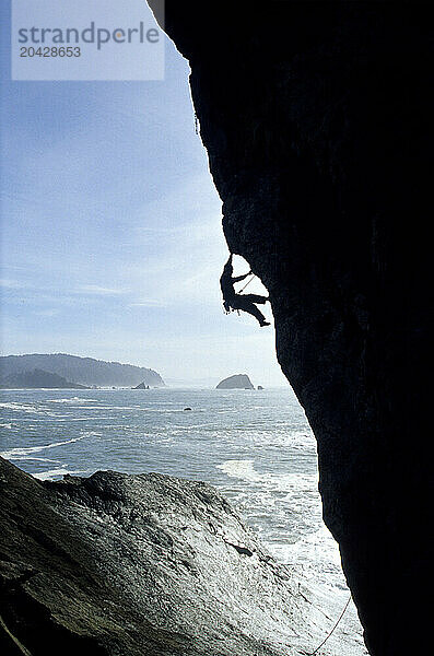 A climber silhouetted above the ocean in Northern California.