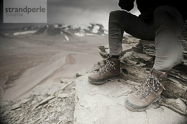 Close up of a mountaineers windblown legs as he surveys Katmai Pass (830m) from the summit of Baked Mountain (1109m) Valley of Ten Thousand Smokes  Katmai National Park  Alaska  U