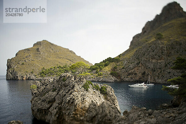 Yachts in rocky cove.