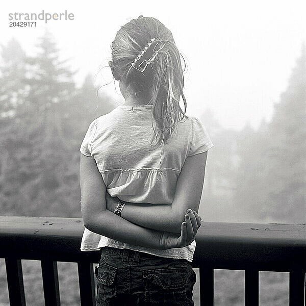 girl looks out to sea on a foggy summer day