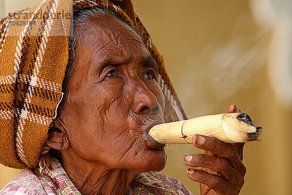 a woman smoking a traditional cheeroot cigar in Bagan  central Myanmar.