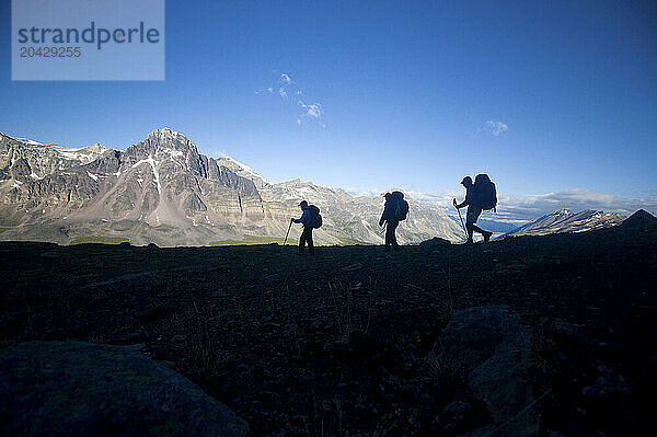 3 backpackers heading down from Jonas Pass in Jasper National Park  Alberta Canada.