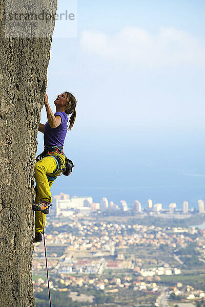 Side view of woman climbing cliff at Olta crag