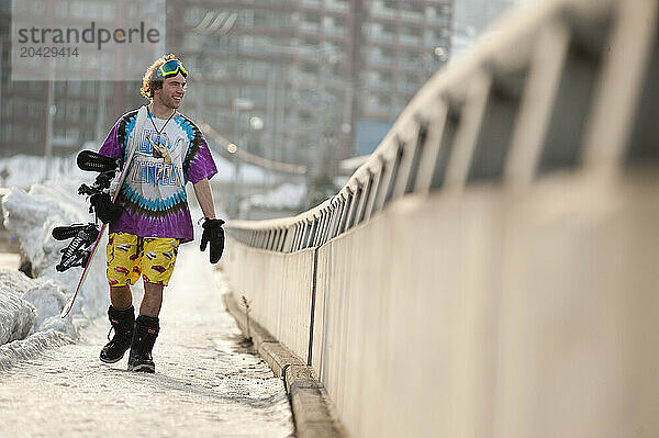 Ryan Paul walks through Otaru  Japan with his snowboard  wearing sushi shorts.