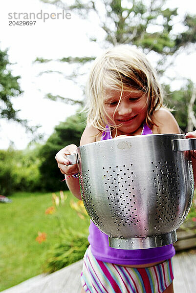 girl barely lifts heavy container of tomatoes