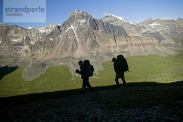 Two backpackers silhouetted against peaks in Jasper National Park  Alberta Canada.